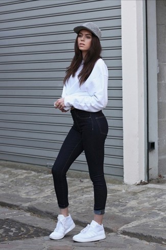 Модный лук: белый свободный свитер, черные джинсы скинни, белые кроссовки, серая кепка