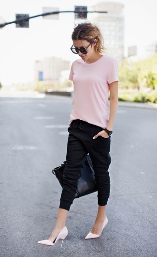 Модный лук: розовая футболка с круглым вырезом, черные спортивные штаны, розовые кожаные туфли, черная кожаная большая сумка