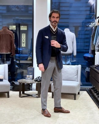 Как носить коричневые кожаные лоферы с темно-синим пиджаком мужчине