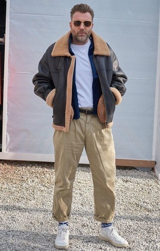 Как носить темно-серую короткую дубленку с белыми кожаными низкими кедами мужчине