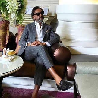 Как носить темно-серый костюм в вертикальную полоску с черными кожаными монками