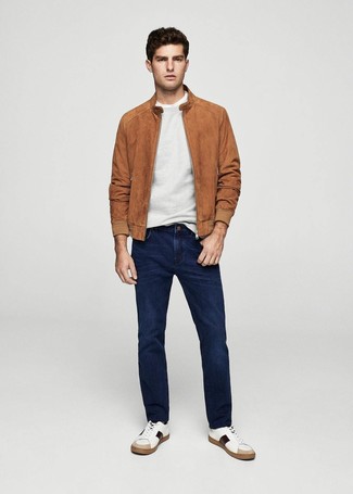 Как носить темно-коричневый замшевый бомбер с синими джинсами мужчине