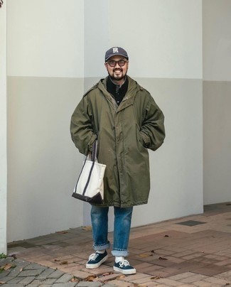 Как носить темно-зеленый дождевик с синими джинсами мужчине