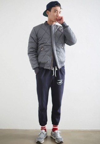 Как носить серый стеганый бомбер с темно-синими спортивными штанами мужчине