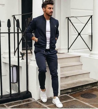 Как носить темно-синий бомбер с белыми кожаными низкими кедами мужчине