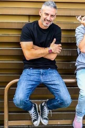 Как носить темно-синие джинсы с черными высокими кедами мужчине