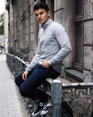 Как носить темно-синие джинсы с черными высокими кедами мужчине