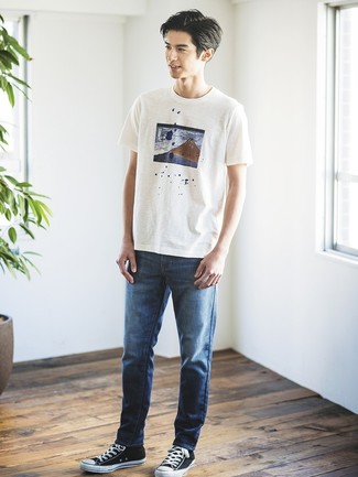 Как носить темно-синие джинсы с черными низкими кедами мужчине