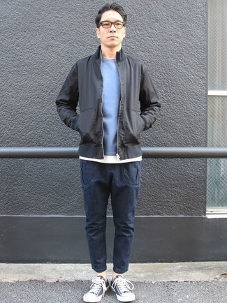 Как носить темно-синие джинсы с черными низкими кедами мужчине