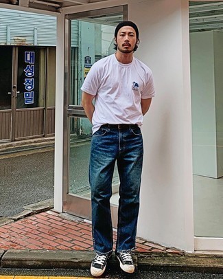 Как носить темно-синие джинсы с черными низкими кедами мужчине