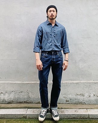 Как носить темно-синие джинсы с черными низкими кедами мужчине