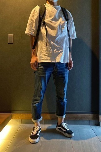 Как носить темно-синие джинсы с черными низкими кедами мужчине