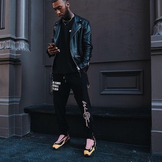 Как носить темно-синюю кожаную косуху с черными спортивными штанами с принтом мужчине