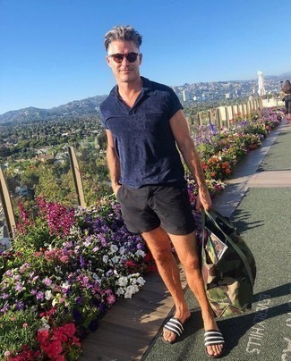 Как носить темно-синюю футболку-поло с черно-белыми сланцами мужчине