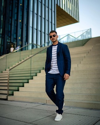 Как носить темно-синий костюм с белыми кожаными низкими кедами