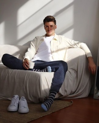 Как носить темно-синие спортивные штаны с белыми низкими кедами мужчине