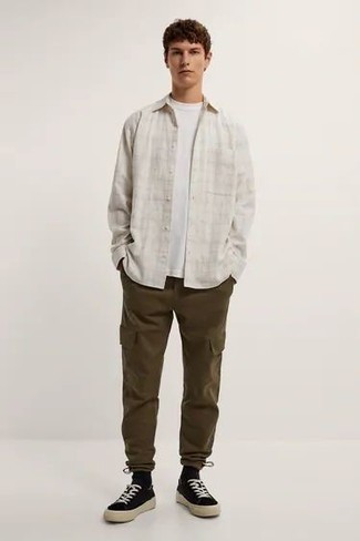 Как носить оливковые брюки карго с черными низкими кедами из плотной ткани