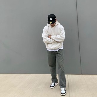 Как носить оливковые джинсы с белыми кожаными низкими кедами мужчине