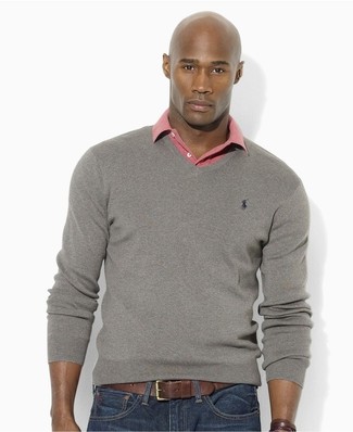 Как носить розовую футболку-поло с темно-синими джинсами мужчине