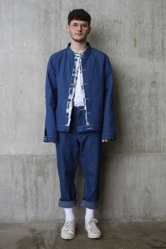 Как носить белые кожаные низкие кеды с темно-синими джинсами мужчине