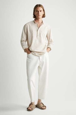 Как носить светло-коричневую рубашку с длинным рукавом с белыми джинсами мужчине в теплую погоду в спортивном стиле: Светло-коричневая рубашка с длинным рукавом и белые джинсы — отличный вариант, если ты ищешь раскованный, но в то же время модный мужской ансамбль. Ты можешь легко приспособить такой лук к повседневным условиям городской жизни, дополнив его светло-коричневыми замшевыми сандалиями.