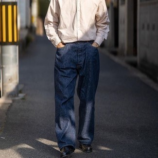 С чем носить темно-синие джинсы в 30 лет мужчине в теплую погоду: Бежевая рубашка с длинным рукавом в паре с темно-синими джинсами — классная идея для воплощения мужского лука в стиле смарт-кэжуал. Не прочь добавить сюда нотку классики? Тогда в качестве обуви к этому ансамблю, выбери черные кожаные лоферы.