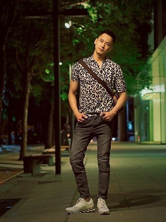 Модный лук: бежевая рубашка с коротким рукавом с леопардовым принтом, темно-серые джинсы, белые кроссовки, темно-коричневая кожаная сумка почтальона