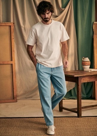 С чем носить светло-коричневые высокие кеды мужчине: Дуэт бежевой футболки с круглым вырезом и голубых джинсов вдохновляет на проявление собственного стиля. Если сочетание несочетаемого привлекает тебя не меньше, чем проверенная классика, заверши этот наряд светло-коричневыми высокими кедами.