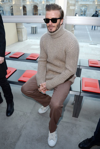 Как David Beckham носит Бежевая шерстяная водолазка, Коричневые шерстяные классические брюки, Белые кожаные низкие кеды с принтом