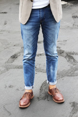 Как носить темно-синие джинсы с коричневыми кожаными оксфордами в 30 лет в теплую погоду: Бежевый пиджак в мелкую клетку и темно-синие джинсы — необходимые вещи в арсенале любителей непринужденного стиля. Этот образ легко обретает свежее прочтение в сочетании с коричневыми кожаными оксфордами.