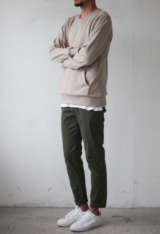 С чем носить темно-зеленые брюки чинос: Бежевый свитшот и темно-зеленые брюки чинос — обязательные элементы образцового мужского гардероба. Вместе с этим луком чудесно выглядят белые кожаные низкие кеды.