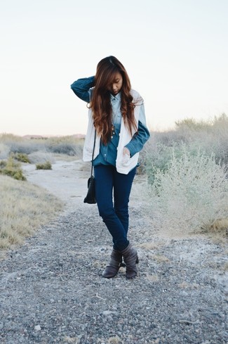 С чем носить синюю джинсовую рубашку женщине: Дуэт синей джинсовой рубашки и темно-синих джинсов скинни позволит создать ощущение "элегантной свободы". Что до обуви, темно-серые кожаные ботильоны — самый уместный вариант.