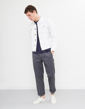 Модный лук: белая джинсовая куртка, темно-синяя футболка с круглым вырезом, темно-серые брюки чинос, белые кожаные низкие кеды