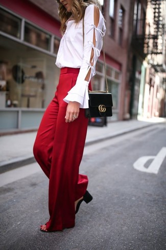 С чем носить красные широкие брюки лето в деловом стиле: Белая классическая рубашка с вырезом в паре с красными широкими брюками может стать превосходным офисным луком. В сочетании с этим луком наиболее выгодно выглядят черные кожаные босоножки на каблуке. Пережить изнурительный летний зной значительно проще, когда на тебе такое сочетание одежды.