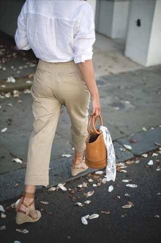 С чем носить светло-коричневые брюки чинос в 30 лет женщине в стиле смарт-кэжуал: Подобный наряд из белой льняной классической рубашки и светло-коричневых брюк чинос легко повторить, а результат превзойдет все твои ожидания. Вместе с этим нарядом чудесно выглядят бежевые босоножки на танкетке из плотной ткани.