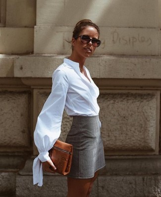 Модный лук: белая классическая рубашка, серая мини-юбка, коричневый кожаный клатч, темно-коричневые солнцезащитные очки