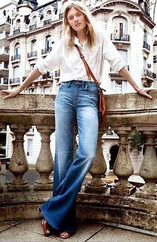 Как носить синие джинсы с белой классической рубашкой женщине: Белая классическая рубашка и синие джинсы будут отлично смотреться в модном гардеробе самых привередливых красавиц. Что же до обуви, можно закончить образ коричневыми кожаными босоножками на каблуке.