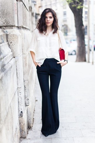 С чем носить белую шелковую классическую рубашку женщине: Комбо из белой шелковой классической рубашки и темно-синих брюк-клеш прекрасно подойдет для офиса. Черные кожаные туфли выигрышно впишутся в лук.