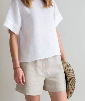 С чем носить белую блузку в 30 лет в жару в стиле смарт-кэжуал: Белая блузка в паре с бежевыми льняными шортами поможет выразить твою индивидуальность.