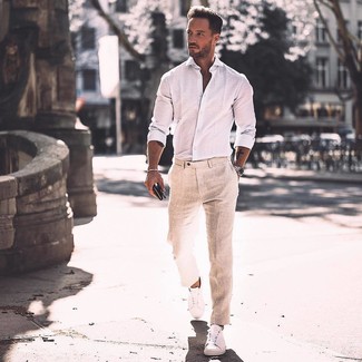 С чем носить светло-коричневые классические брюки мужчине в стиле смарт-кэжуал: Сочетание белой рубашки с длинным рукавом и светло-коричневых классических брюк позволит воссоздать строгий мужской стиль. Дерзкие мужчины завершат образ белыми кожаными низкими кедами.