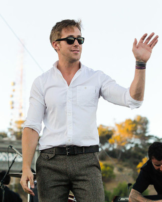 Как Ryan Gosling носит Белая рубашка с длинным рукавом, Серые шерстяные классические брюки, Черный кожаный ремень, Черные солнцезащитные очки