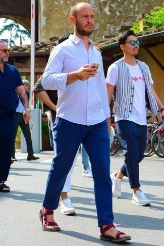С чем носить синие брюки чинос в теплую погоду в спортивном стиле: Белая рубашка с длинным рукавом и синие брюки чинос — необходимые элементы в гардеробе мужчин с чувством стиля. Пурпурные сандалии из плотной ткани создадут легкое настроение.