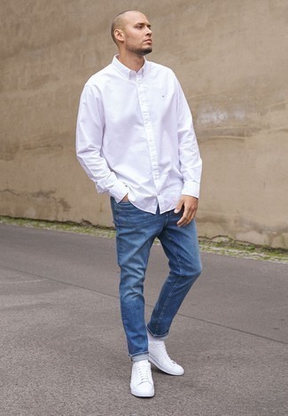 Как носить синие джинсы с бело-темно-синими низкими кедами из плотной ткани мужчине лето: Сочетание белой рубашки с длинным рукавом и синих джинсов позволит выглядеть аккуратно, а также выразить твою индивидуальность. В тандеме с этим ансамблем великолепно будут выглядеть бело-темно-синие низкие кеды из плотной ткани. В жаркие летние деньки подобное сочетание вещей придется очень кстати.