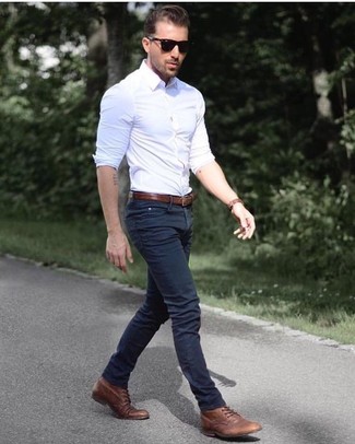 Как носить темно-синие джинсы с коричневыми повседневными ботинками в 30 лет мужчине весна в стиле смарт-кэжуал: Современным парням, которые предпочитают быть в курсе последних тенденций, советуем обратить внимание на это сочетание белой рубашки с длинным рукавом и темно-синих джинсов. Этот ансамбль получит свежее прочтение в сочетании с коричневыми повседневными ботинками. Этот весенний ансамбль придется по душе самому придирчивому денди.