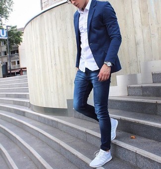 Как носить синие джинсы с серыми кроссовками мужчине в теплую погоду: Белая рубашка с длинным рукавом в паре с синими джинсами — замечательная идея для создания мужского образа в элегантно-деловом стиле. Этот ансамбль неплохо дополнят серые кроссовки.