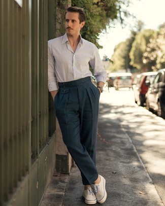 Какие низкие кеды носить с темно-синими классическими брюками мужчине: Белая рубашка с длинным рукавом в вертикальную полоску и темно-синие классические брюки — хороший пример изысканного мужского стиля. Тебе нравятся незаурядные решения? Можешь завершить свой образ низкими кедами.