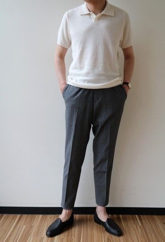 С чем носить классические брюки за 40 лет мужчине в жару в стиле смарт-кэжуал: Белая футболка-поло прекрасно гармонирует с классическими брюками. Такой образ получает новое прочтение в тандеме с черными кожаными лоферами.