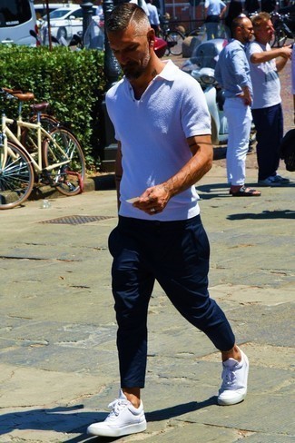 Какие футболки-поло носить с белыми низкими кедами за 40 лет мужчине в жару: Ансамбль из футболки-поло и темно-синих брюк чинос вдохновляет на проявление своей индивидуальности. Что касается обуви, можно закончить лук белыми низкими кедами.