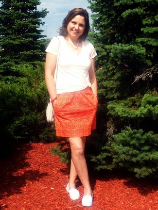 С чем носить мокасины женщине: Белая футболка с v-образным вырезом и оранжевая мини-юбка с принтом — отличное решение для дам, которые никогда не сидят на месте. В паре с этим образом органично выглядят мокасины.