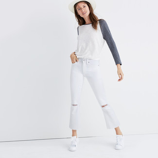 С чем носить рваные джинсы в 20 лет женщине: Белая футболка с длинным рукавом смотрится гармонично в сочетании с рваными джинсами. Белые низкие кеды чудесно впишутся в ансамбль.